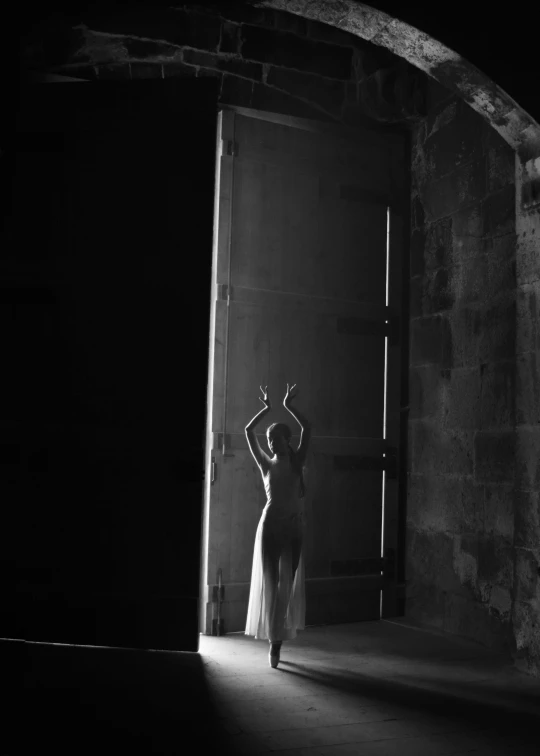 a woman in a dark room looking into a doorway