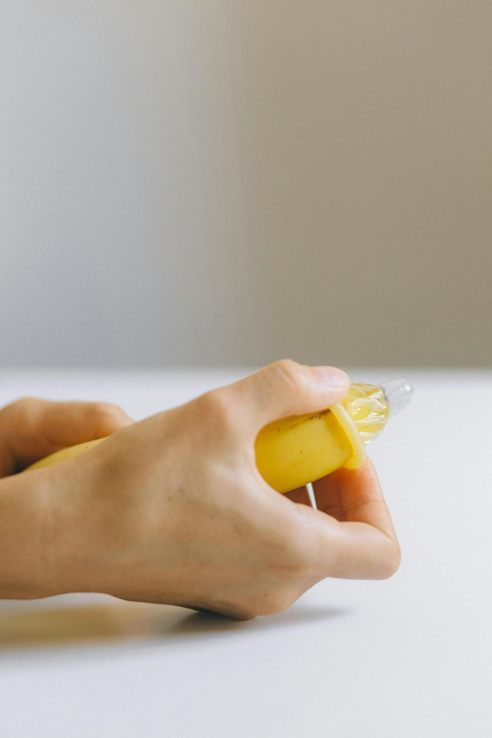 a person is spreading a banana onto a white counter