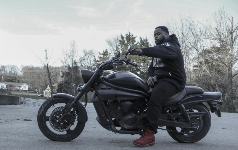 a man in sweatpants on a black motorcycle