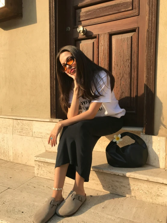 a woman sitting on steps with sunglasses on