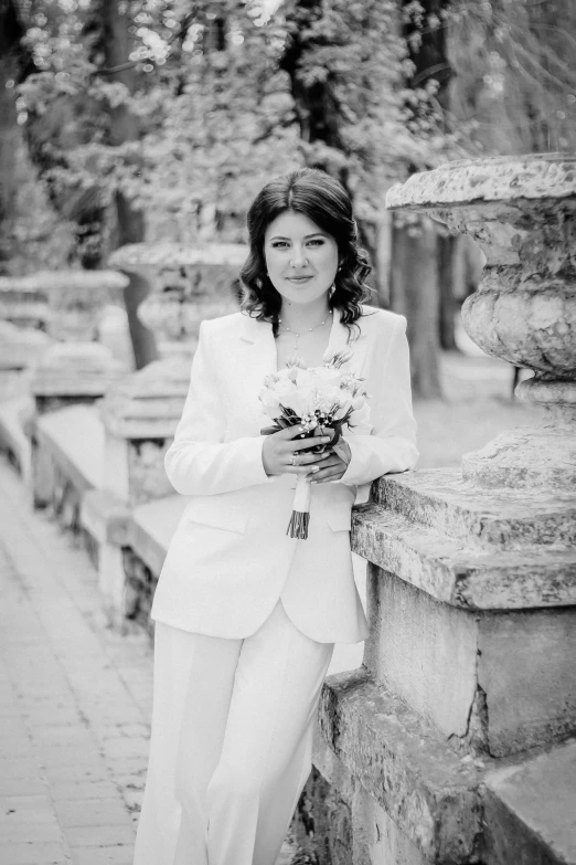 a woman wearing a suit and holding a flower in her hand