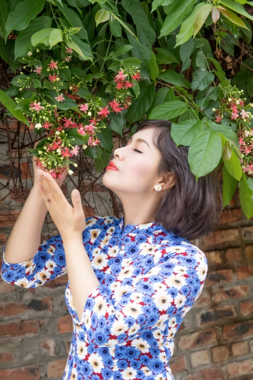 a woman is smelling flowers with her hands