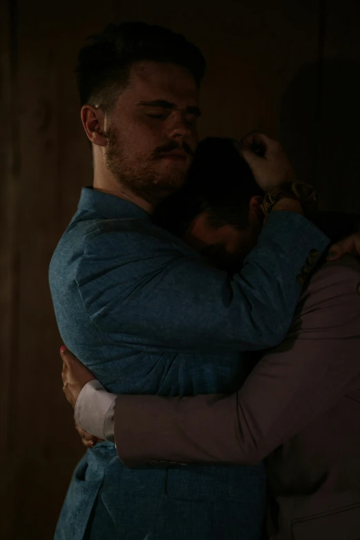 a man and a woman hug in the dark