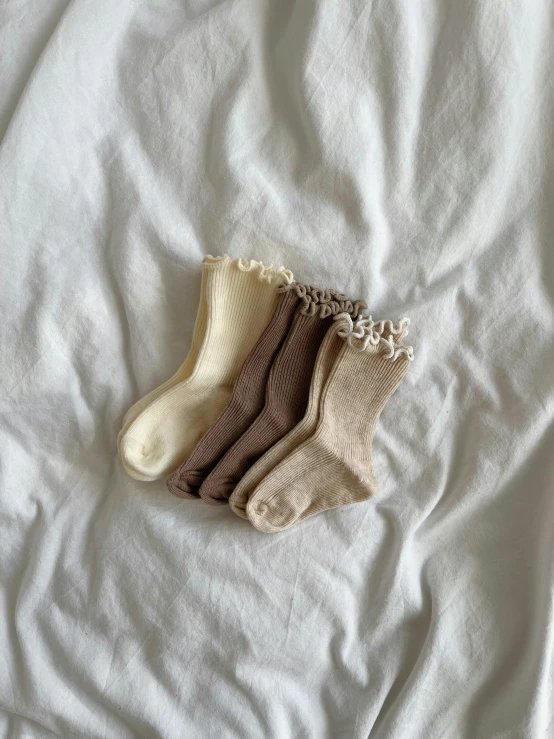 three socks on a white blanket are hanging