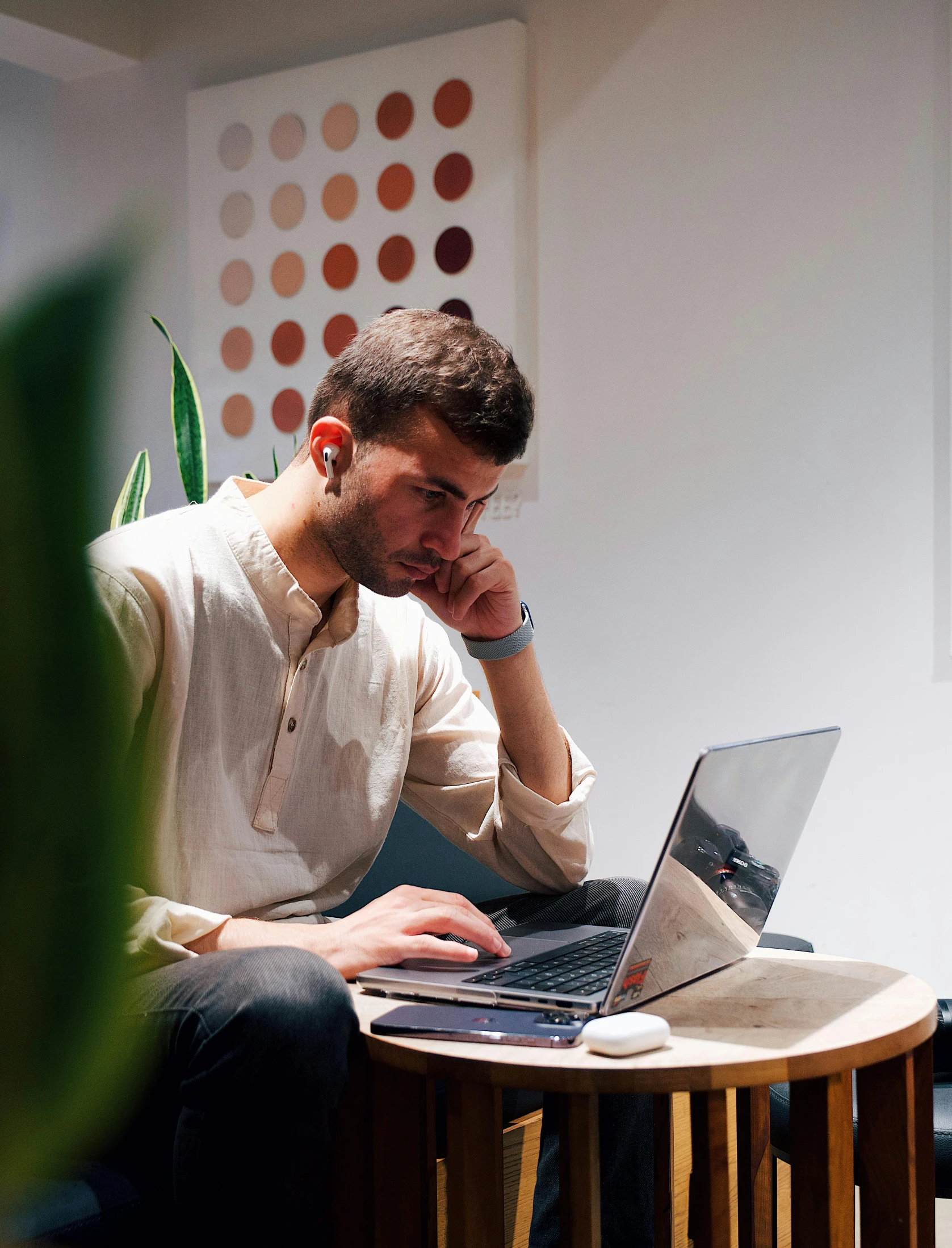 a man in white shirt working on a laptop computer