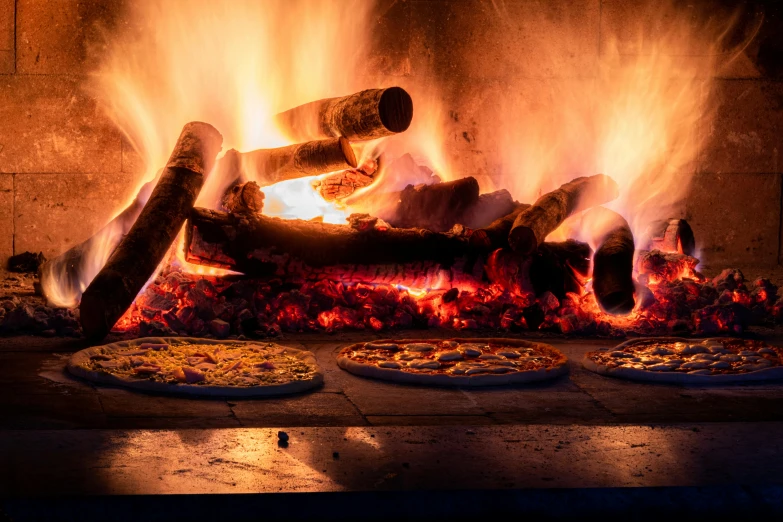 a burning fire that has pizzas on it