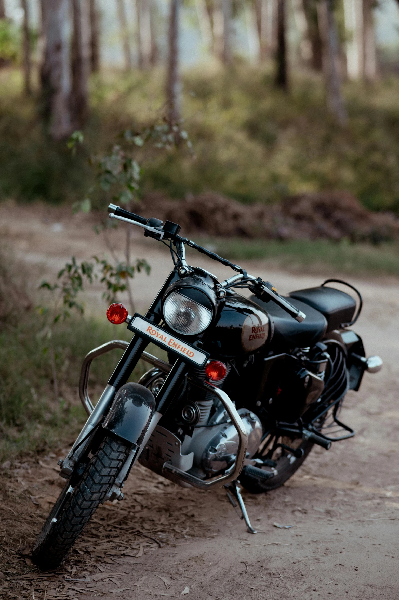 a motorcycle parked on a trail in a forest