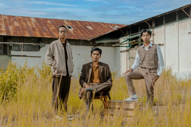 two young men and one old gentleman sitting on top of a chair