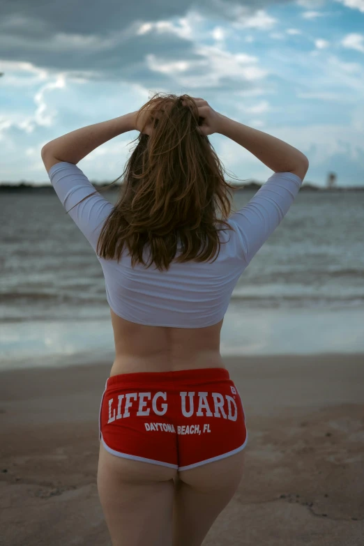 a woman on a beach looking at the ocean