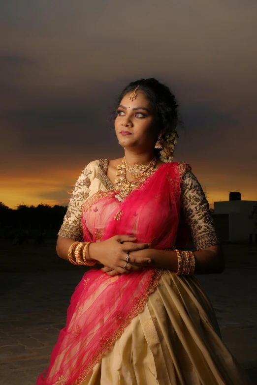 indian woman standing outdoors in saree at sunset