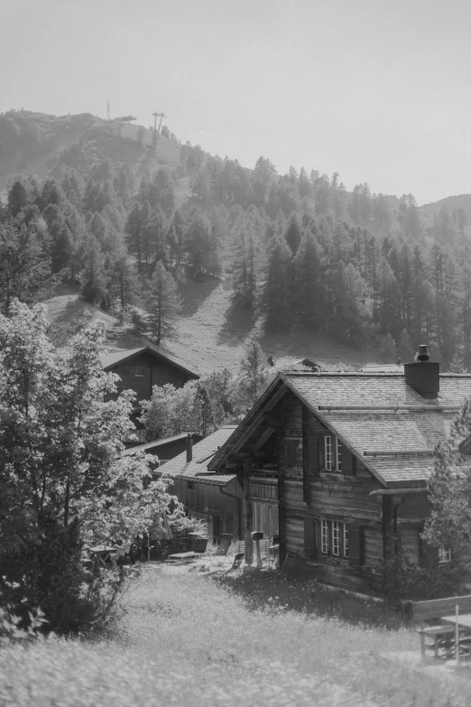 a cabin nestled within the mountains in an old pograph