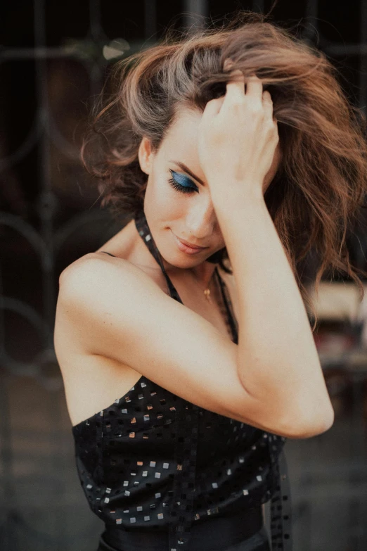 a woman with blue eyes standing next to a black fence