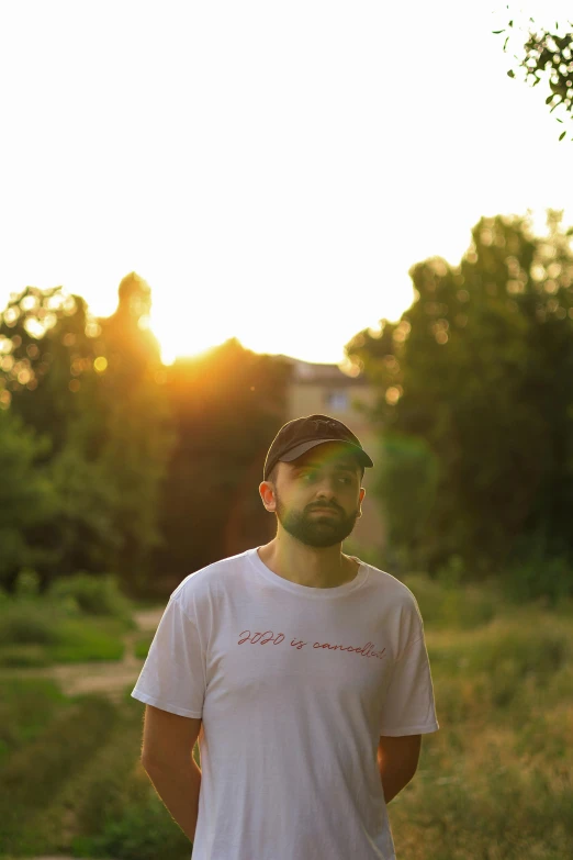 a bearded man is standing in the sunset