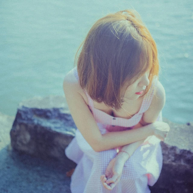 girl in white dress leaning her elbows on a wall