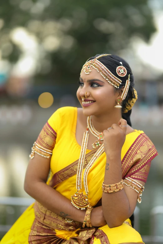 a woman in yellow is smiling for the camera