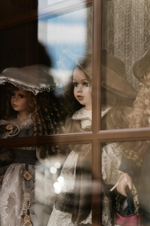 two dolls in an old fashion shop window