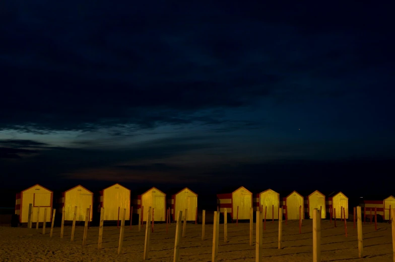 multiple rows of beach huts lined up on the sand