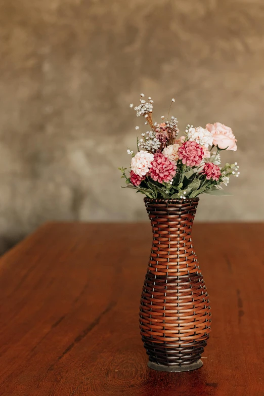 a brown basket filled with pink and white flowers