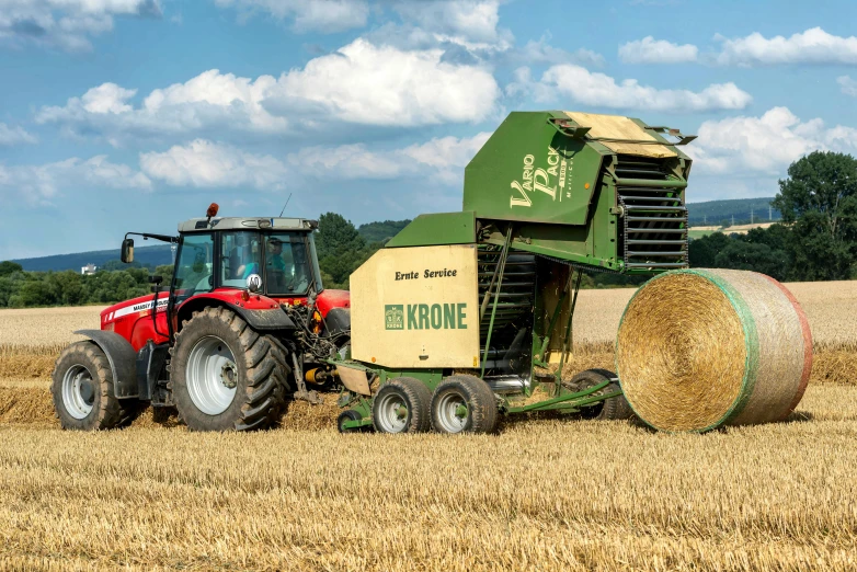 a big hay bail being hed by a tractor