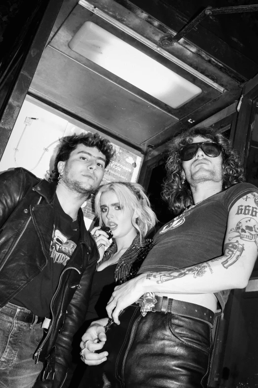 some punk friends posing for the camera with one woman holding a gun