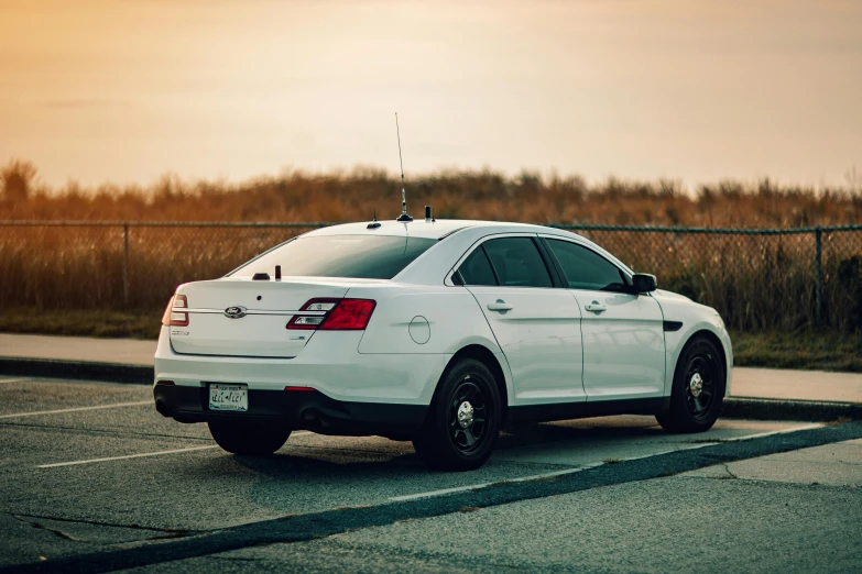 the white car is parked in a lot