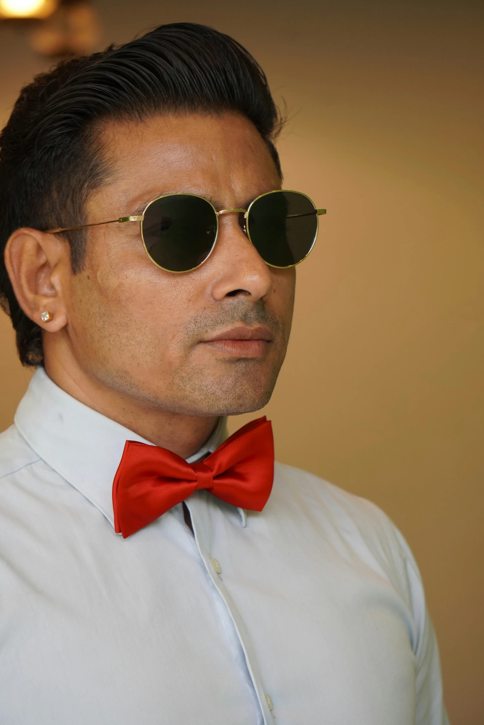 a close up of a person wearing sunglasses and a bow tie