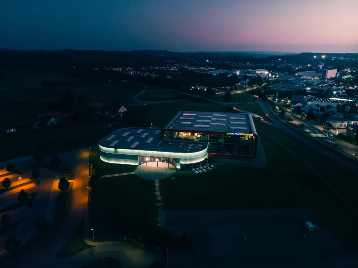 an aerial s of an illuminated building and the city at night