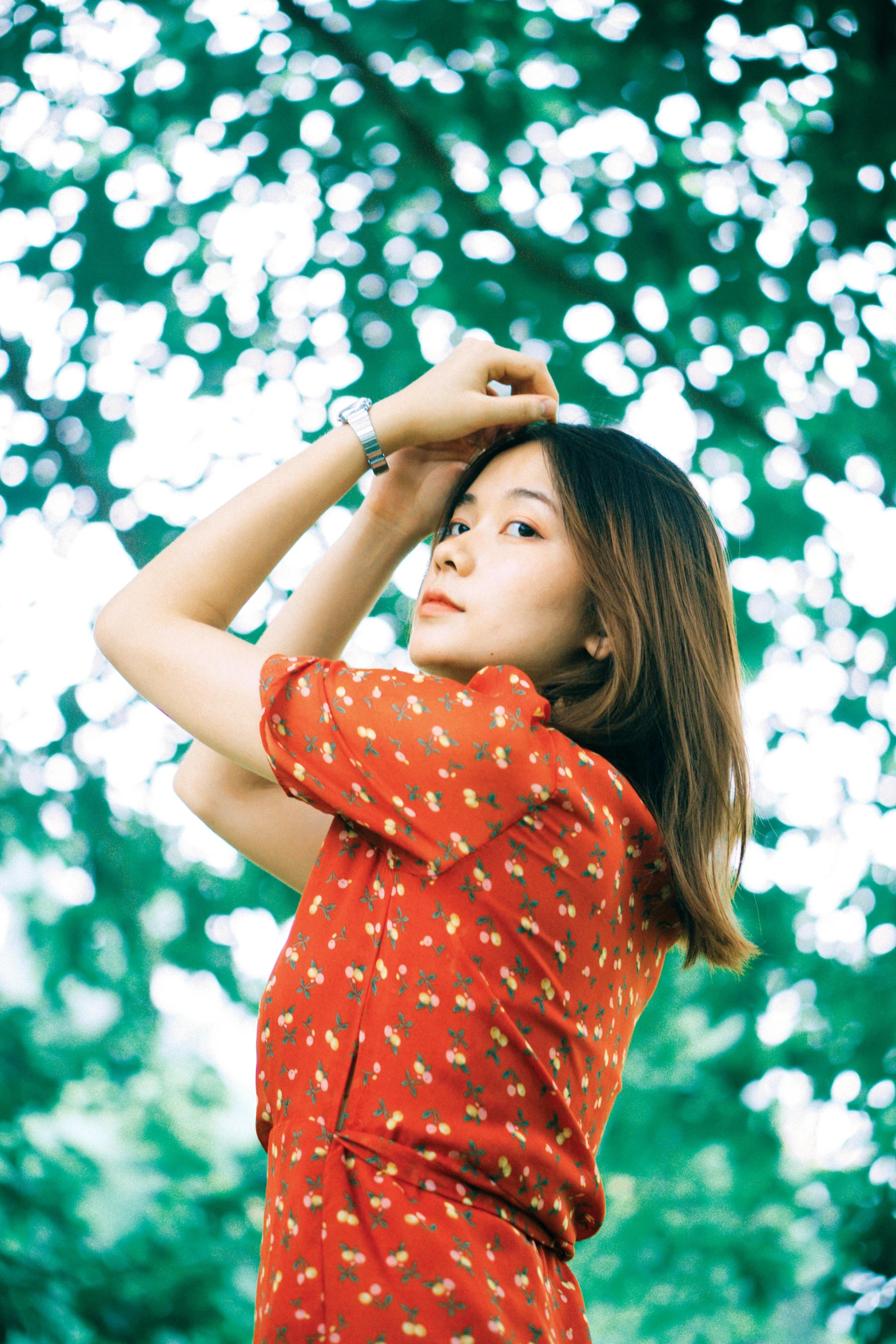 a woman posing for a picture in front of trees