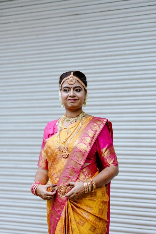 a young woman in a traditional sari standing outdoors