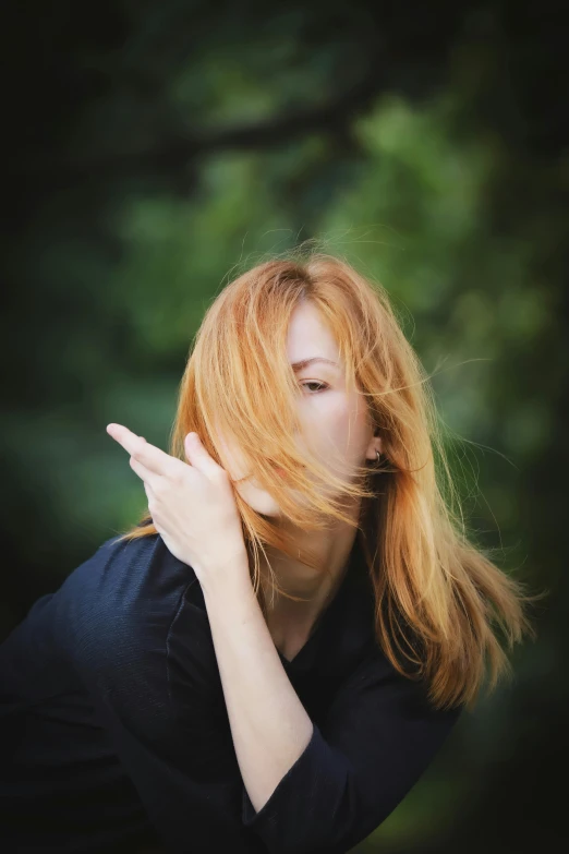 a woman with red hair has her hands together