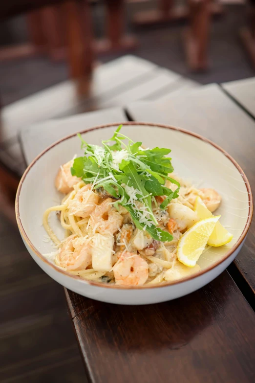 there is a bowl of pasta with shrimp and parsley