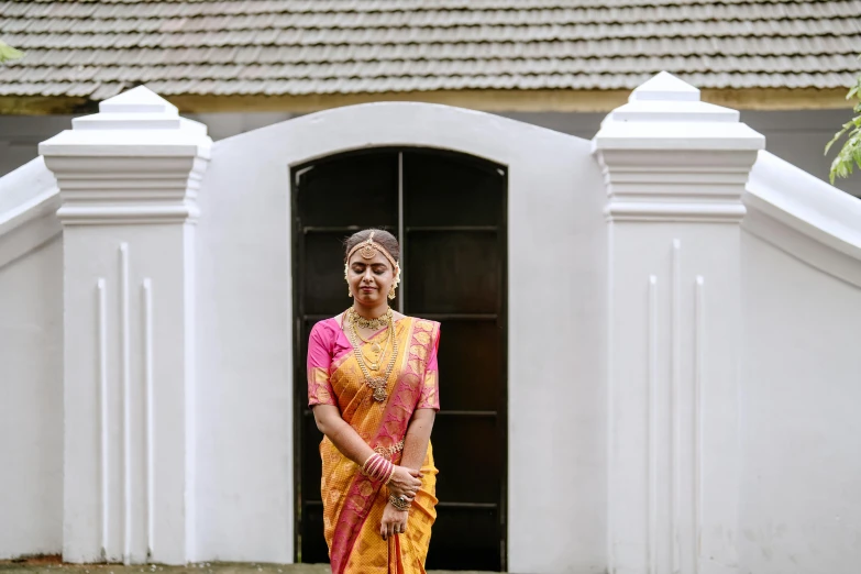 a woman in traditional dress standing outside a house