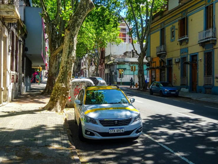 the white car is driving down the street