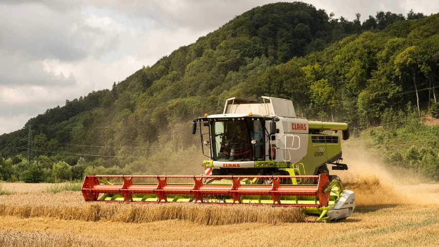 a green and red harvest machine in a field