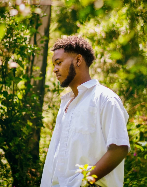 a black man wearing a shirt in a forest