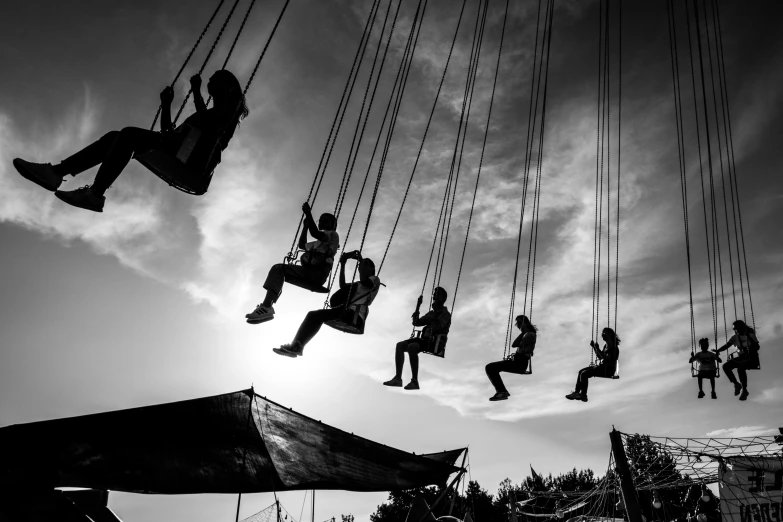 several people are riding down some ropes in the air