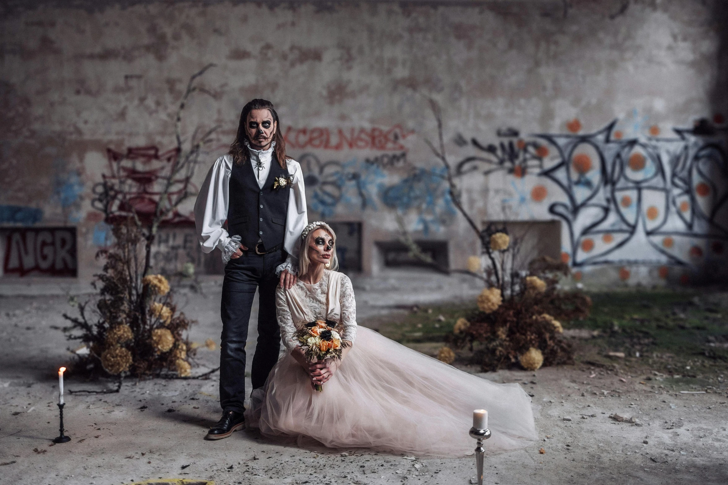 a bride and groom stand in front of some decorated objects