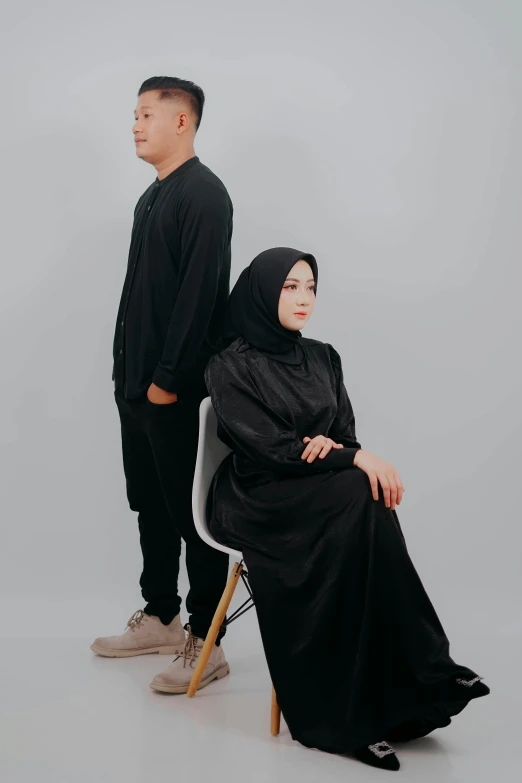 two people dressed in black sitting next to each other