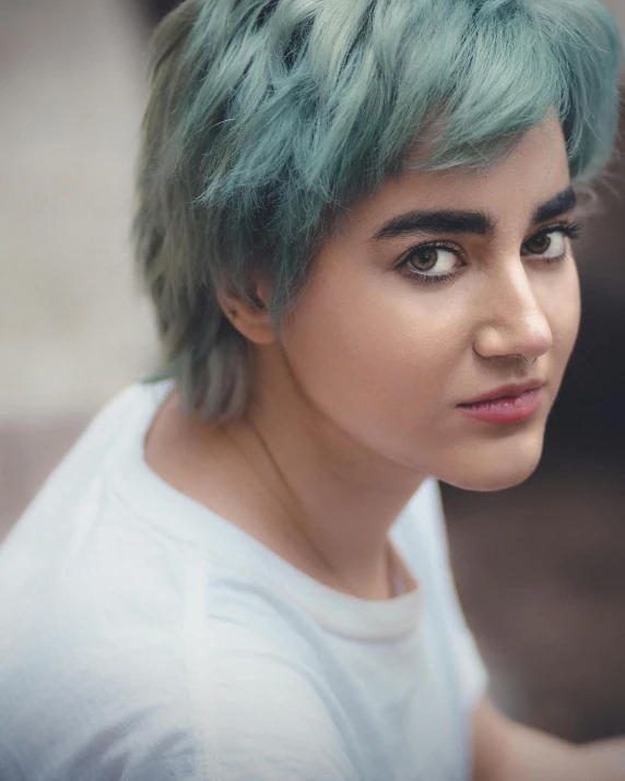 a young woman with dyed green hair in a white top