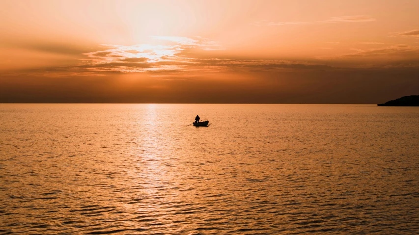 a boat floating on a lake near a large island