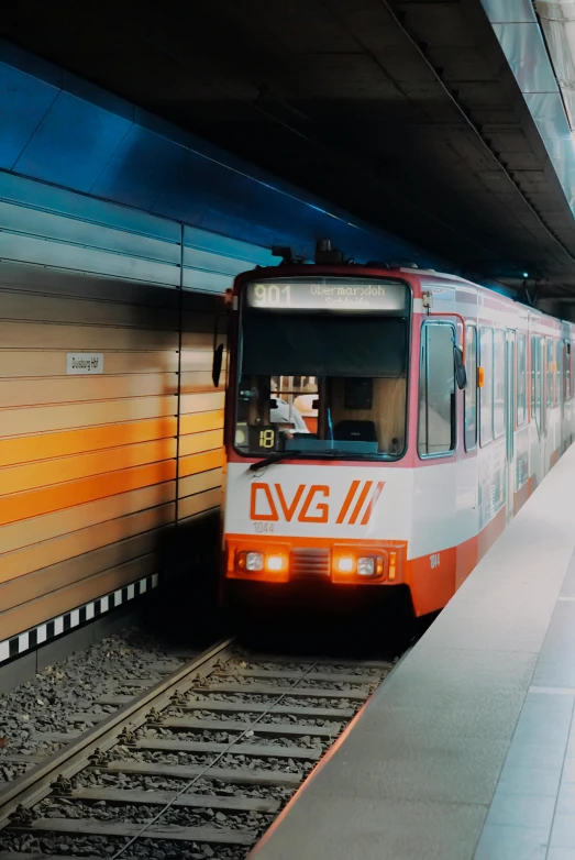 a red train pulling into a tunnel that is on tracks