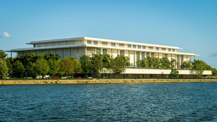 a large building sitting on top of a hill near the water