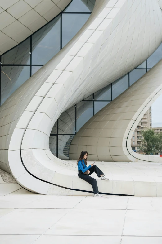 the woman is posing near a large building