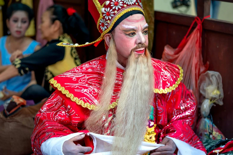 a man in a red costume and long blond hair