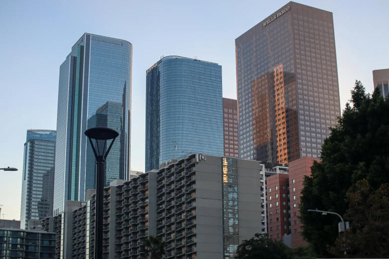 a city with tall buildings is reflected in the glass of a skyscr