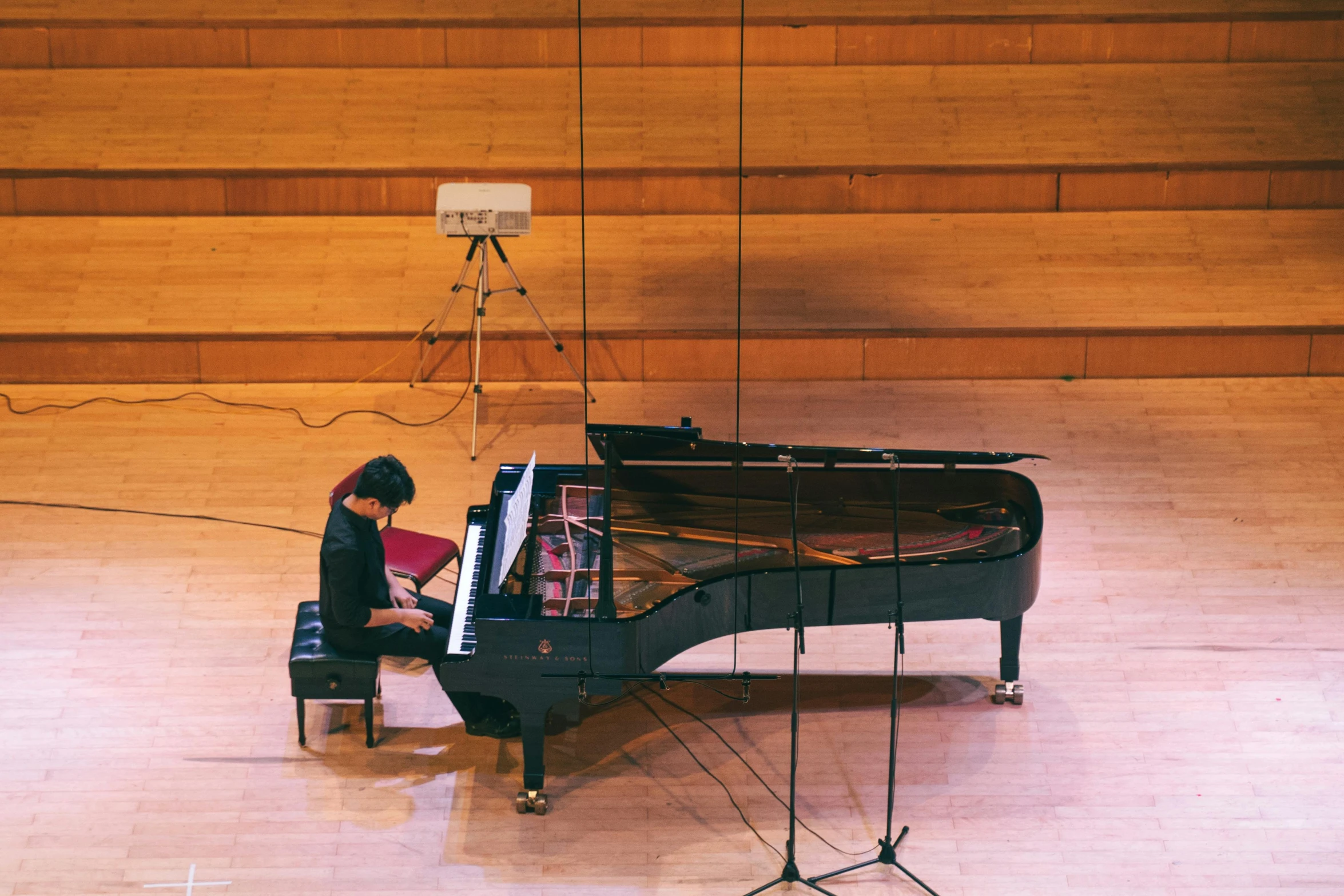 a  sits at the piano in a music school