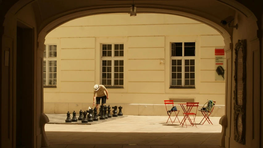 a person plays chess in front of an archway