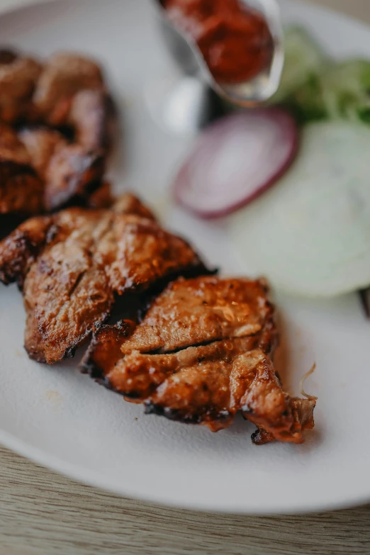 there is meat and vegetables on a white plate