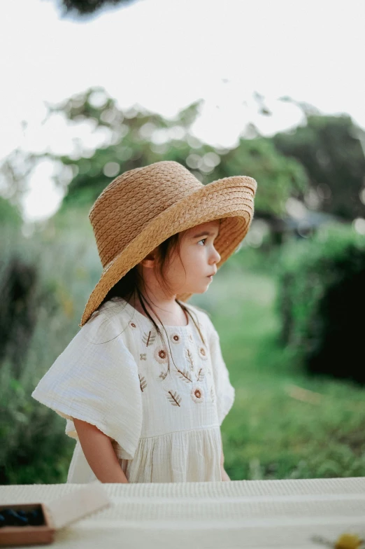 the girl in the hat is looking out from a deck