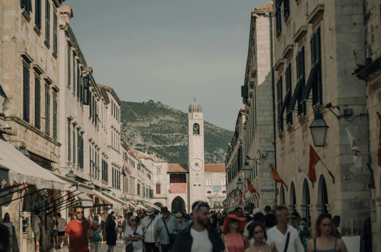 a street filled with people and a tower in the background